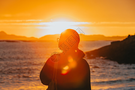 人水和谐一名身着面罩 健康概念 生命和自由的旅客 在海滩上多彩日落前穿戴面罩的旅行者假期创造力生活福利喜悦女孩旅行女性天空动机背景