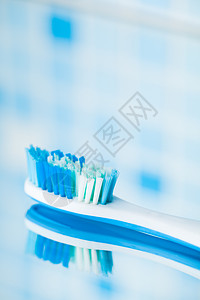 蓝瓷砖背景上的牙刷 有镜像反射图片