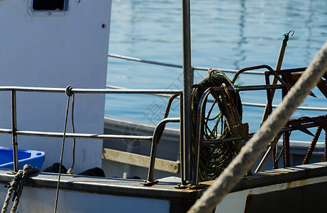 一艘渔船停泊在港口的切割船上的一件物件渔夫舰队海洋钓鱼绳索海浪热带码头索具运输图片