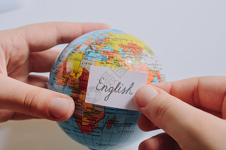 手持全球使用英文文字的纸上随笔纸说话英语教育语言学指导字典学生班级发音学校图片
