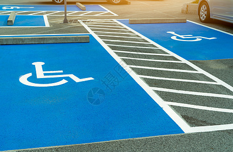 超市或购物中心为残疾司机预留的沥青停车场 残疾人车位 沥青停车场上的轮椅标志油漆 残疾人停车场服务医院交通白色医疗条纹商业运输路图片