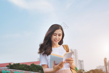 年轻美少女在一座城市观桥上读书幸福微笑女孩快乐大学成人教育女性女士校园图片