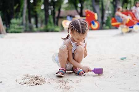 玩沙箱游戏的小女孩 在挖掘沙沙沙幕建筑沙沙图夏季日塑料幼儿园建筑幸福太阳女儿女孩操场活动玩具图片