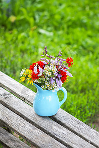 在木凳上的蓝色陶瓷花瓶里 盛满鲜花花束婚礼植物群玻璃桌子花瓣园艺树叶礼物植物图片