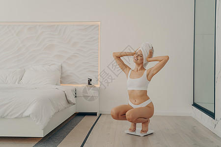 在现代卧室室内的称号上 漂亮的年轻 健康的女模特儿图片