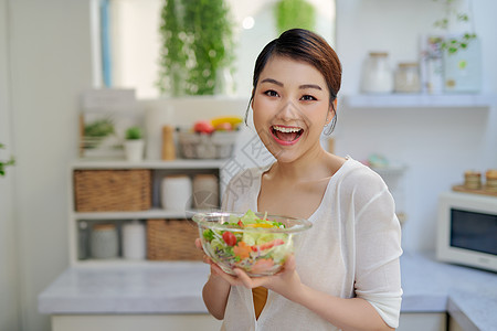 在家里吃新鲜沙拉的年轻美少女女性房子公寓饮食快乐健康女士图片