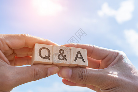 在木制立方体上 用有背景的手握着Q和字母表 问答的含义帮助教学网络男人商业测验论坛教育社区社会图片