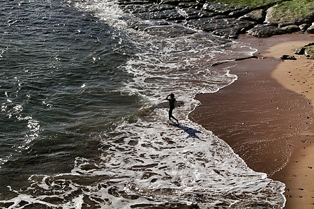 葡萄牙里斯本海滩的Surfer冲浪者蓝色海浪运动海景岩石海滩石头海洋游客图片