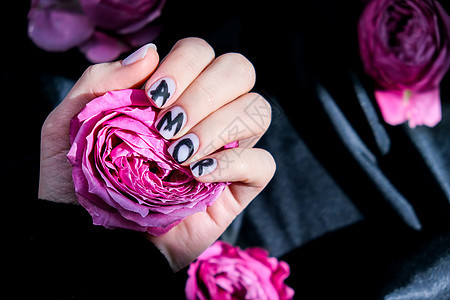 指甲修指甲上的 AMOR 字样在黑色丝绸织物上挂着粉红色的玫瑰花 最小的平躺自然 女手 爱凝胶护理艺术抛光设计美甲玫瑰美容手指化图片