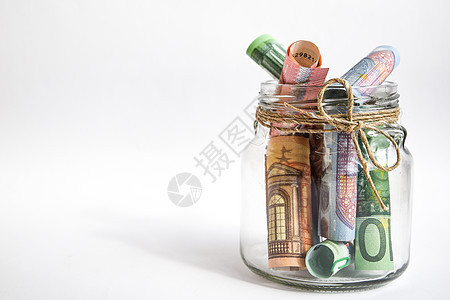 带有欧元纸币的玻璃罐在白色背景上被隔离欧元卷了你养老金财富银行金融大学瓶子玻璃货币投资储蓄图片