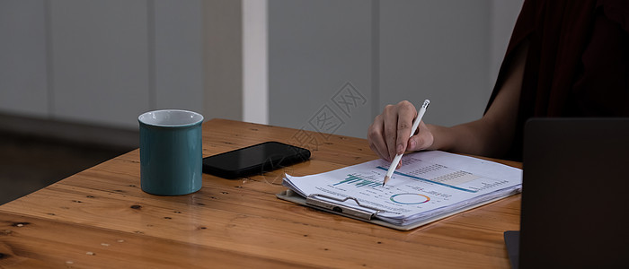 特写的手 女商务人士用铅笔指向本月的图表 并使用计算器计算下个月提高质量的计划 财务会计概念图片