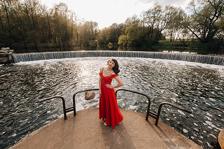 日落时 在公园湖边穿红裙子的女孩公主奢华海报红色魔法自由跑步女王派对太阳图片