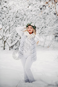 一个穿着白色衣服的女人在寒冷的冬天森林里的画像 在白雪覆盖的冬季森林里 头戴花环的女孩花园雪花艺术女士假期裙子新年木头季节镜头图片