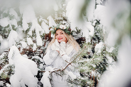 一个穿着白色衣服的女人在寒冷的冬天森林里的画像 在白雪覆盖的冬季森林里 头戴花环的女孩帽子雪花裙子花园镜头女士艺术木头假期新年图片