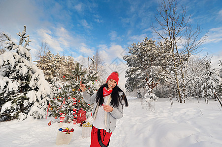 冬季森林里快乐的女孩在圣诞树附近自拍 圣诞节那天 一个女人在白雪覆盖的森林里微笑季节花园幸福裙子雪花帽子红色衣服艺术假期图片