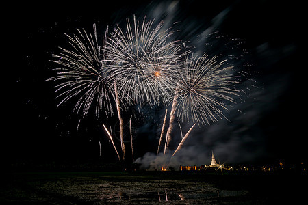 黄昏时在稻田上放着巨大的 多彩的烟火黑色烟花天空假期红色派对节日念日焰火展示图片