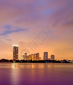 紫色城市河边附近的小镇 在夜里阴云的一天背景