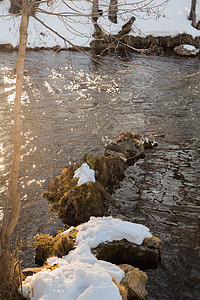 冬天的风景 一条有阳光的河流 在水和积雪的河岸上假期孤独反射场景水池天气晴天强光速度树木图片