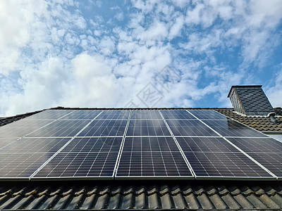 太阳能电池板在带有云反射的住宅屋顶上产生清洁能源太阳能光伏生态环境反射土地安装房子家庭建筑学图片