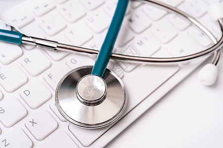 白色背景的计算机键盘上的立体显像镜 物理学家撰写医疗案例长期护理治疗概念 特写 宏观 复制空间记录案件桌子处方卫生工作诊断健康技图片