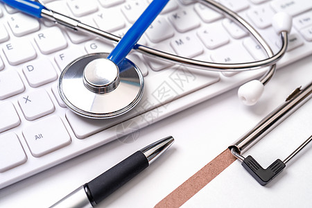 白色背景的计算机键盘上的立体显像镜 物理学家撰写医疗案例长期护理治疗概念 特写 宏观 复制空间医疗保险健康医生笔记案件蓝色保健桌图片