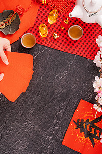 中国农历一月新年的设计理念女人拿着 给红包 红包 红包 作为幸运钱 顶视图 平躺 头顶上方 春字的意思是春天来了茶壶硬币假期礼物图片