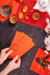 中国农历一月新年的设计理念女人拿着 给红包 红包 红包 作为幸运钱 顶视图 平躺 头顶上方 春字的意思是春天来了礼物金子假期灯笼图片