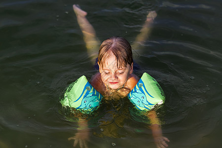 在炎热的夏日 一个快乐的孩子正在河里游泳 在水库游泳 一个幸福的家庭在夏天玩得开心 在水中嬉戏岛屿闲暇乐趣池塘泳装父亲童年海洋太图片
