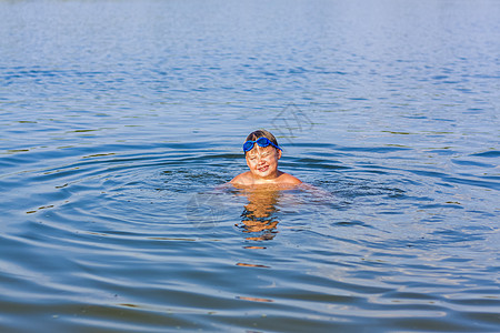 在炎热的夏日 一个快乐的孩子正在河里游泳 在水库游泳 一个幸福的家庭在夏天玩得开心 在水中嬉戏孩子们闲暇笑声乐趣童年池塘泳装沙滩图片