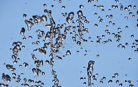 蓝天上喷泉流的水滴天空运动喷泉溪流蓝色背景图片