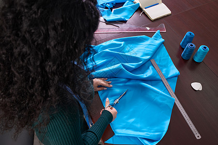 在裁缝制衣室 餐饮店 切割蓝布的服装师桌子工作粉笔剪刀纺织品职业衣服设计师磁带剪裁图片