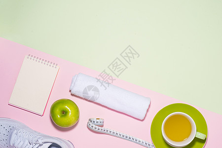 健康的概念 喷水器 茶叶 苹果和测量胶带 在糊面彩色背景上图片