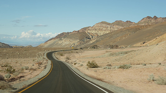 前往美国加利福尼亚州死亡谷的公路旅行 在美国搭便车旅行 公路 五颜六色的光秃秃的山脉和气候干旱的荒野 从车上看 内华达之旅视角砂图片