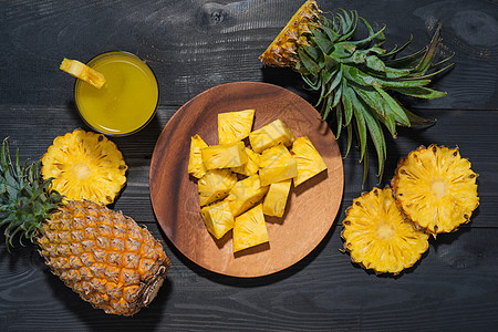 黑木桌上菠萝果和菠萝果杯的顶端视图黑色水果热带果汁饮料玻璃黄色食物营养饮食图片