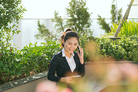 喝咖啡场景女商务人士在花园公园里使用智能手机电话女孩成人咖啡商务女士微笑女性人士杯子背景