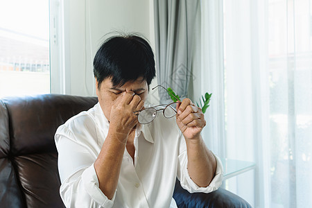 疲惫的老妇人看完纸质书后摘下眼镜 按摩眼睛 因长时间戴眼镜而感到不适 眼睛疼痛或头痛紧张房间弱点头晕压力燃烧女性疾病女士图片