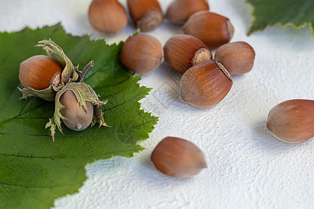 浅色背景的黑桃子和绿叶 含有有益的维他命和矿物质温度谷物疾病卫生玻璃榛子青菜杏仁配料种子图片