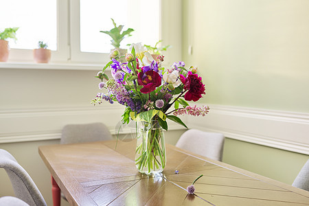 茶壶里桌子上盛着明亮鲜花植物群花瓶风格装饰虹膜牡丹玻璃房子花瓣礼物图片