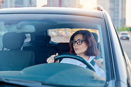 招聘司机素材有眼镜的中年女司机 开车的女司机驾驶旅行城市运输速度中年人商业安全座位女性背景