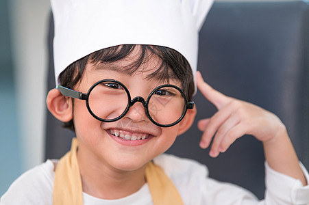 画像可爱的亚洲幸福小男孩有兴趣在家里的厨房里和妈妈一起做饭 人们的生活方式和家庭 自制食品和配料的概念 烘烤圣诞蛋糕和饼干图片