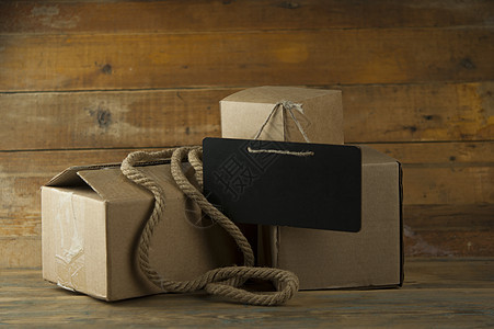 木制背景的纸板纸箱绳索牛皮纸黑板商业礼物展示回收小样盒子船运图片