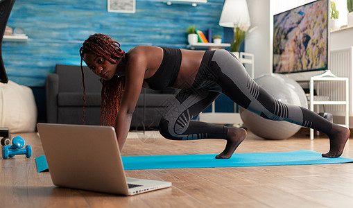 身强健健健健健健的黑人女子在健身垫上跑滑板图片
