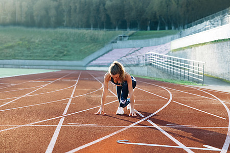 女运动员在晨光中的跑道上训练 准备在体育场运动跑道上的薄雾中起飞的年轻女子赛跑者 运动员准备开始 女运动员 有氧运动图片