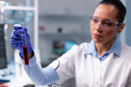 分析工作在化学病毒实验的血液试管的化学家医生图片