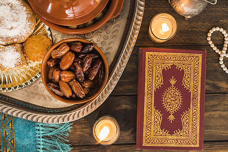阿拉伯食物附近的古兰经蜡烛 高品质照片图片