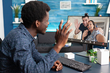 非裔美国人在网上视频电话上与朋友聊天交谈的非洲人通讯朋友们技术屏幕房间男人呼唤桌子电脑互联网图片