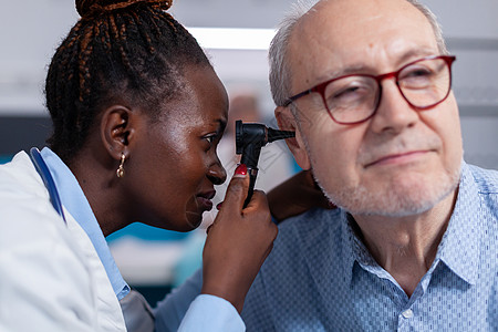 黑色医生用耳腔检查的眼透镜贴近黑人医生耳朵诊所治疗乐器临床药品技术耳科卫生访问图片