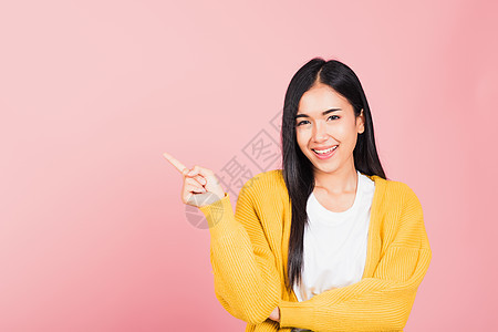 妇女站着微笑 指指空空的手指空间乐趣手势女性管理人员天蓝色女孩工作室头发快乐喜悦图片