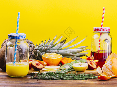 黄色背景下的水果迷迭香汁梅森罐砧板 高品质照片图片