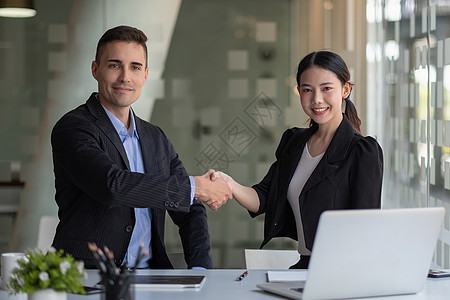 快乐的白人男性和亚洲女性握手 成功的商务人士握手后对两家公司来说都是很好的交易 企业并购理念图片